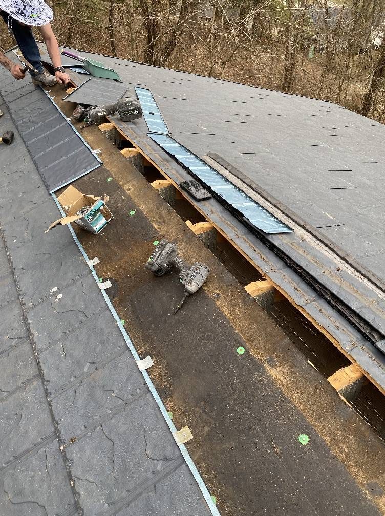 New asphalt shingles and metal flashing installed at a roof valley